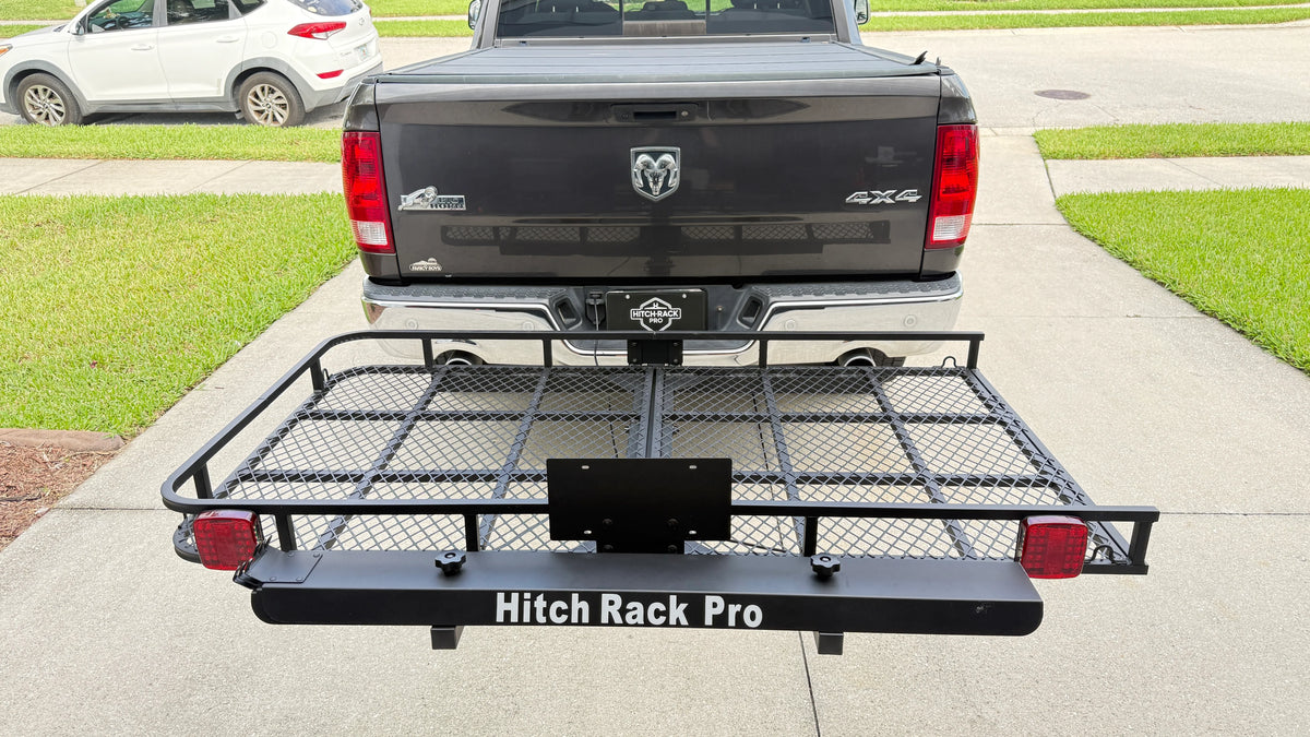 Black Hitch Rack Pro truck cargo carrier mounted on the rear of a dark gray Ram 4x4 pickup truck, shown in a residential driveway.